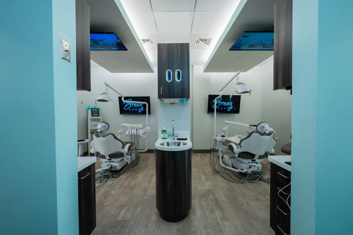 modern dental treatment room at breez dental with two chairs, ceiling-mounted screens, and advanced equipment